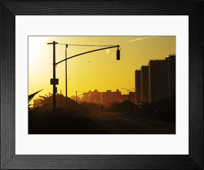 Framed Print : A man walks down Shore Front Parkway surrounded by debris pushed onto the streets by Framed Print : A man walks down Shore Front Parkway surrounded by debris pushed onto the streets by