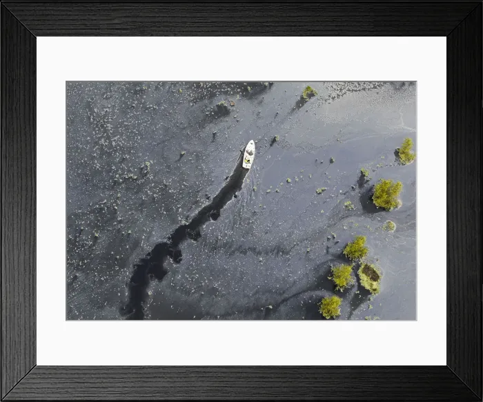 Framed Print : Residents on a boat navigate down a flooded farm in the municipality of Cajica near in