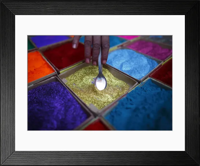 Framed Print : A street vendor spreads vermilion powder used for worship during the Tihar festival in