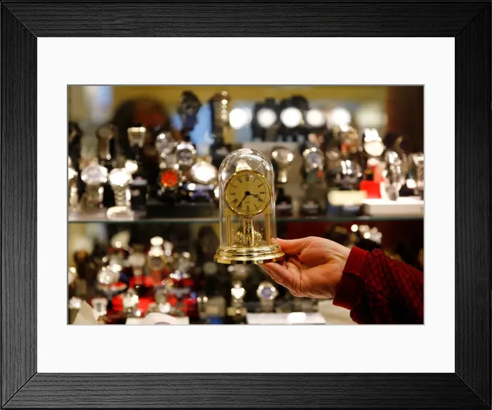 Framed Print : A watchmaker holds a clock in his store in Vienna Framed Print : A watchmaker holds a clock in his store in Vienna