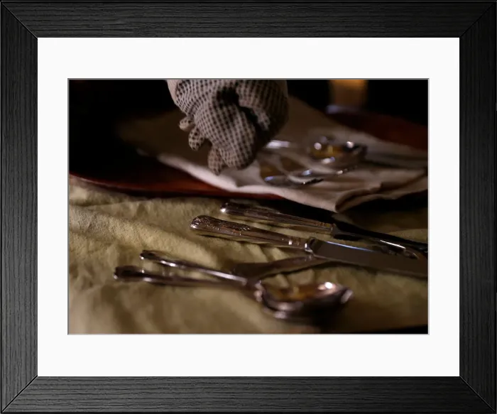 Framed Print : A woman polishes silver cutlery at her home in Valletta
