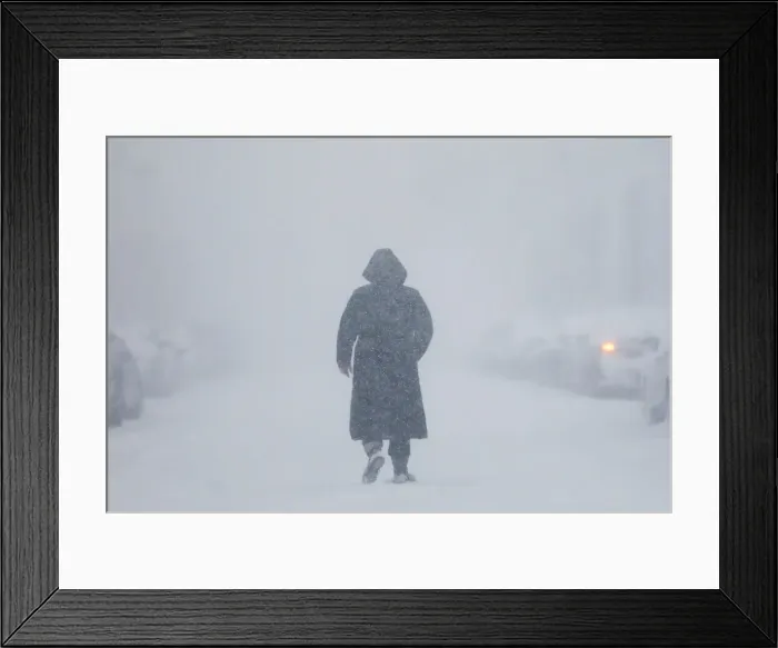 Framed Print : A woman walks down the street during a blizzard in Long Beach Framed Print : A woman walks down the street during a blizzard in Long Beach