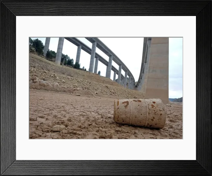 Framed Print : A barrel lies under freeway bridges on the dried out ground of the partially empty Framed Print : A barrel lies under freeway bridges on the dried out ground of the partially empty