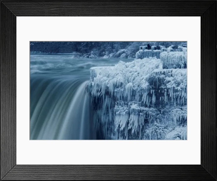 Framed Print : A lone visitor takes a picture near the brink of the ice covered Horseshoe Falls in Framed Print : A lone visitor takes a picture near the brink of the ice covered Horseshoe Falls in