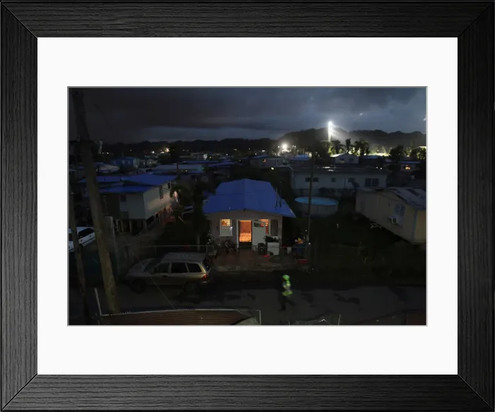 Framed Print : A house is lit up with the help of a generator next to houses in the dark after Hurricane Framed Print : A house is lit up with the help of a generator next to houses in the dark after Hurricane