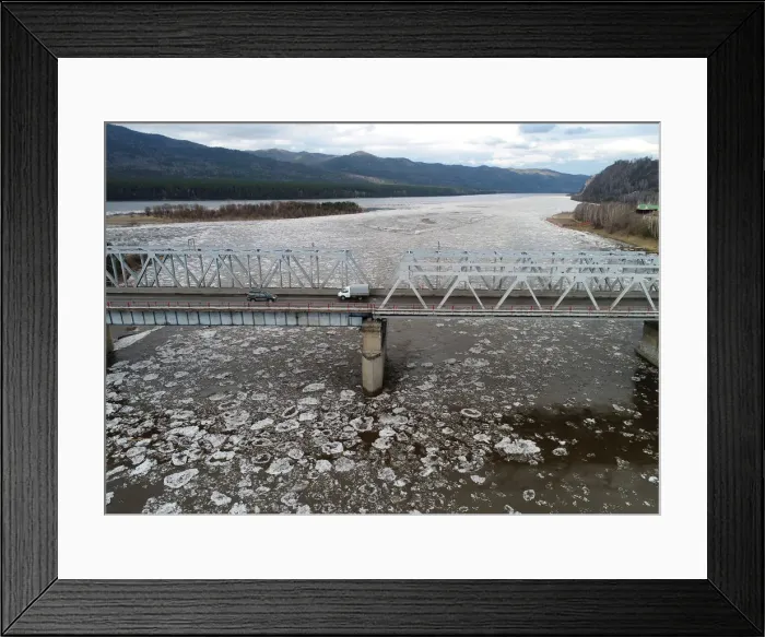 Framed Print : A view shows vehicles driving along a bridge across the Mana River during an ice drift Framed Print : A view shows vehicles driving along a bridge across the Mana River during an ice drift