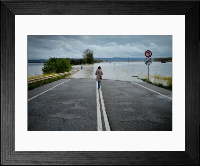 Framed Print : A woman stands on a road flooded by waters from the River Ebro Framed Print : A woman stands on a road flooded by waters from the River Ebro