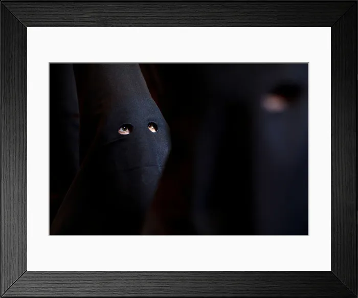 Framed Print : Penitents of Los Estudiantes brotherhood wait for the start of the procession during Framed Print : Penitents of Los Estudiantes brotherhood wait for the start of the procession during