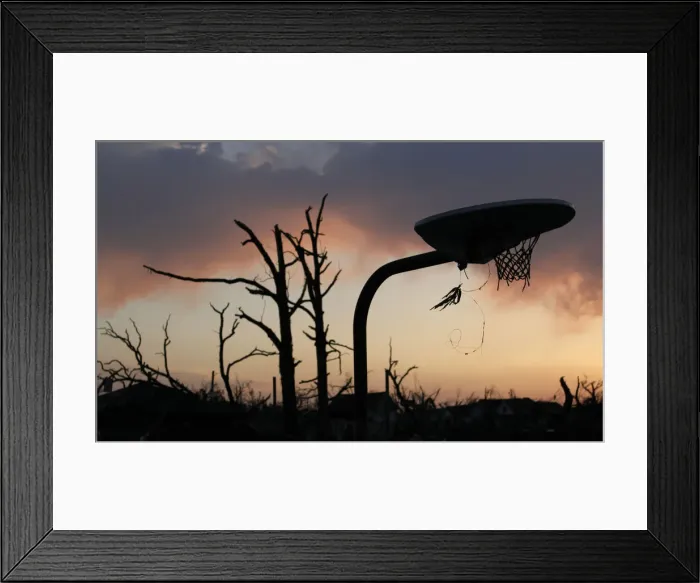 Framed Print : A bent basketball goal stands in a park next to a bare tree after a devastating tornado Framed Print : A bent basketball goal stands in a park next to a bare tree after a devastating tornado