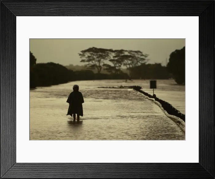 Framed Print : A man walks through the flooded Jakarta-Merak toll road to reach near Serang
