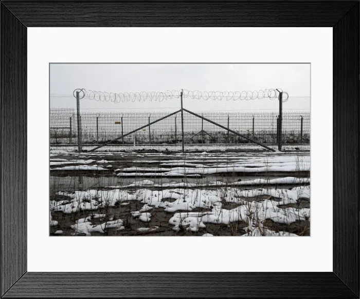 Framed Print : A wire fence is seen next to the village of Asotthalom Framed Print : A wire fence is seen next to the village of Asotthalom