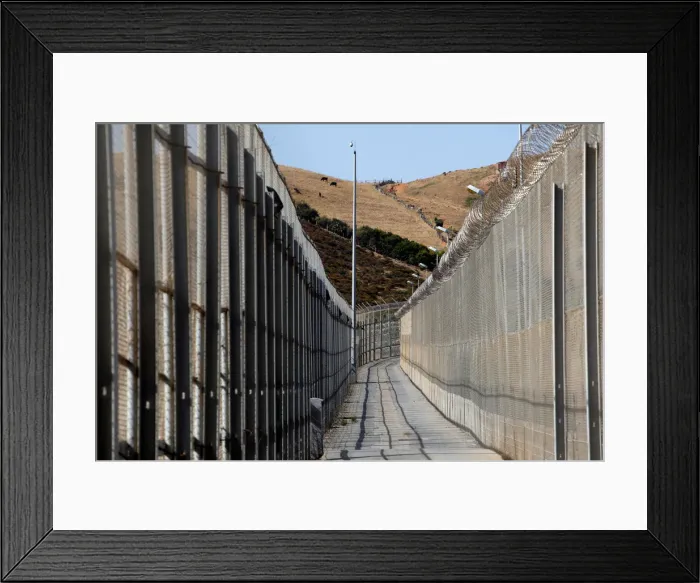Framed Print : The border fence separating Spains northern enclave Ceuta and Morocco is seen from Ceuta