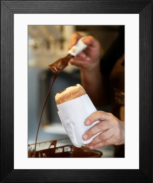 Framed Print : A vendor prepares a traditional Trdelnik sweet pastry in Prague
