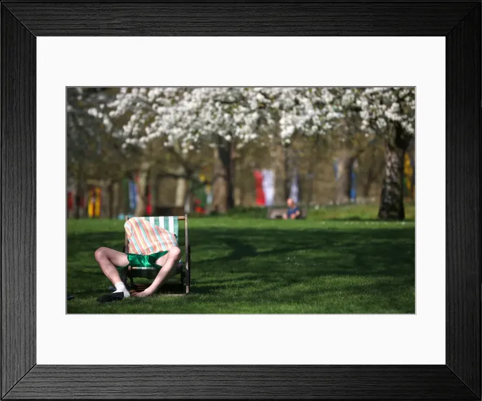 Framed Print : A man relaxes in the sunshine in St James Park in central London