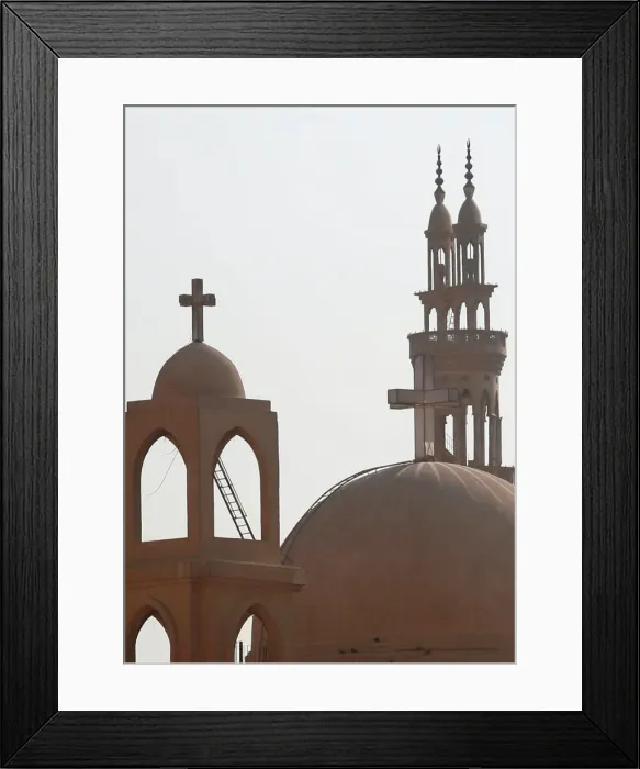 Framed Print : Minarets of a mosque and the cross above a church is seen during the Muslim holy fasting Framed Print : Minarets of a mosque and the cross above a church is seen during the Muslim holy fasting