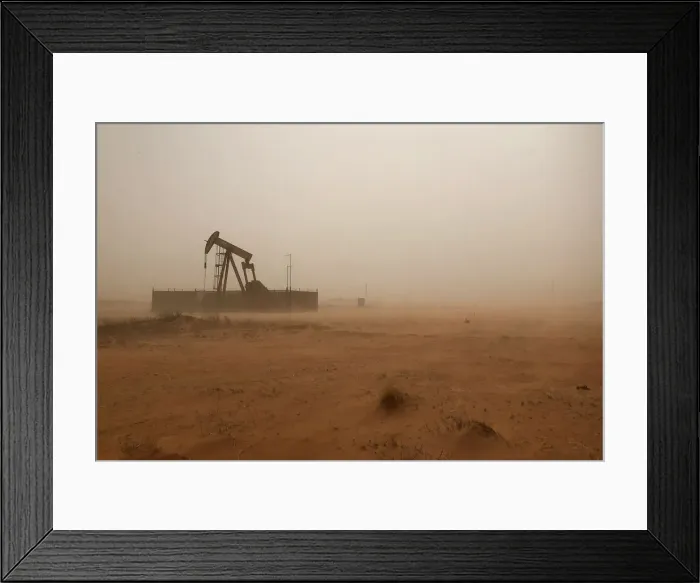 Framed Print : A pump jack lifts oil out of a well during a sandstorm in Midland
