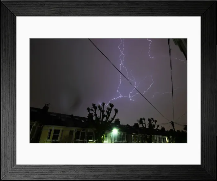 Framed Print : Lightning is seen from a bedroom window as it strikes above a street in south London