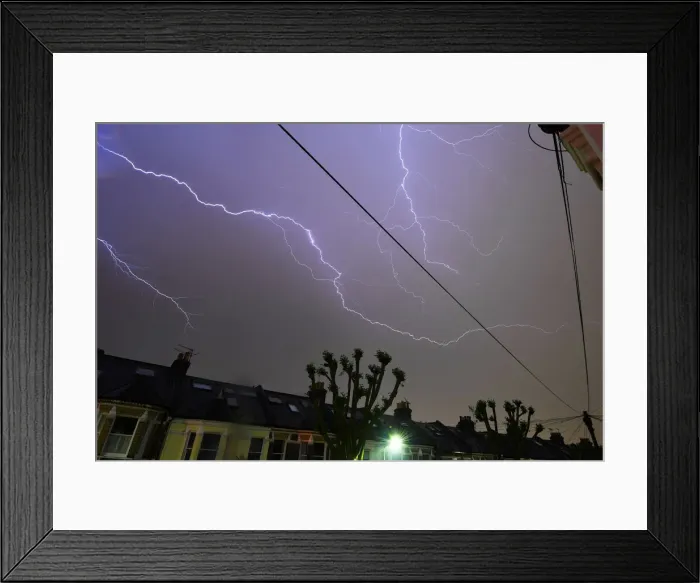 Framed Print : Lightning is seen from a bedroom window as it strikes above a street in south London Framed Print : Lightning is seen from a bedroom window as it strikes above a street in south London