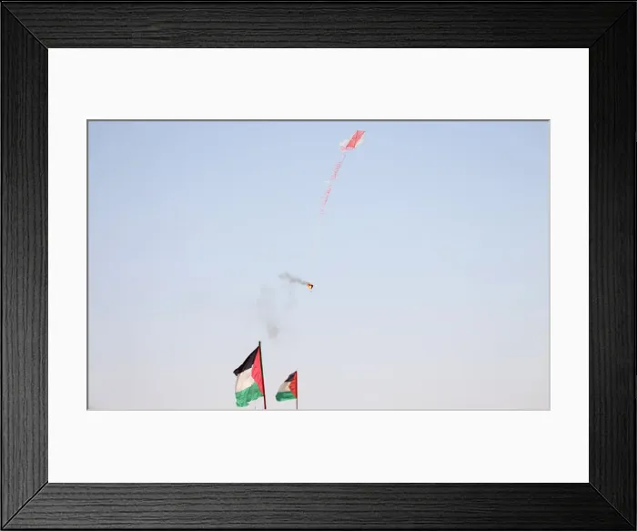 Framed Print : Kite loaded with a flammable material is flown by Palestinian demonstrators to be thrown Framed Print : Kite loaded with a flammable material is flown by Palestinian demonstrators to be thrown