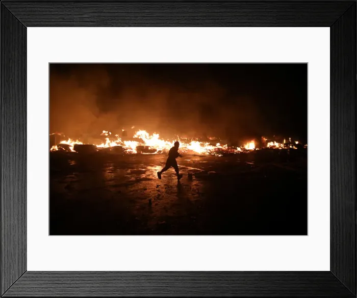 Framed Print : A man runs next to fire at a market in Port-au-Prince Framed Print : A man runs next to fire at a market in Port-au-Prince