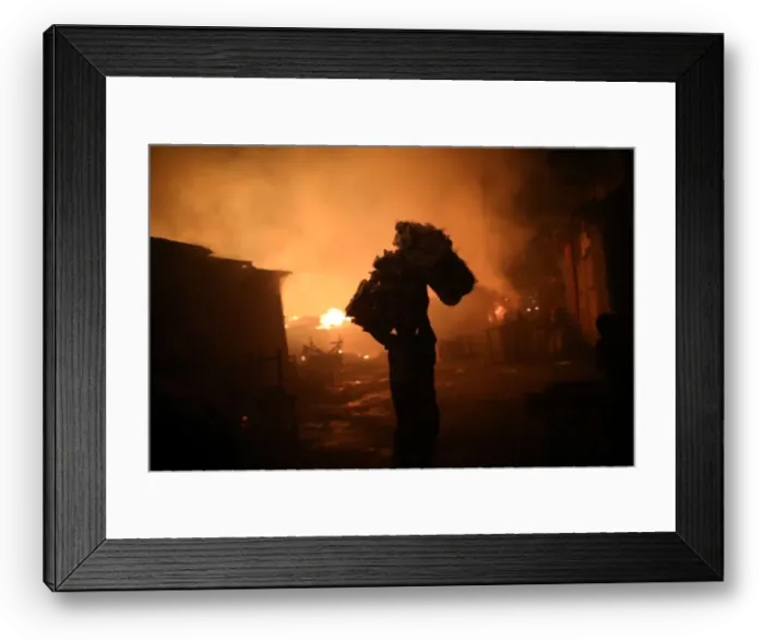 Framed Print : A man carries goods out of a fire at a market in Port-au-Prince Framed Print : A man carries goods out of a fire at a market in Port-au-Prince