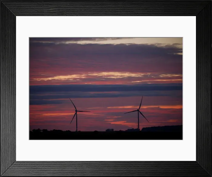 Framed Print : Power-generating windmill turbines are pictured during sunset at a wind park in Framed Print : Power-generating windmill turbines are pictured during sunset at a wind park in