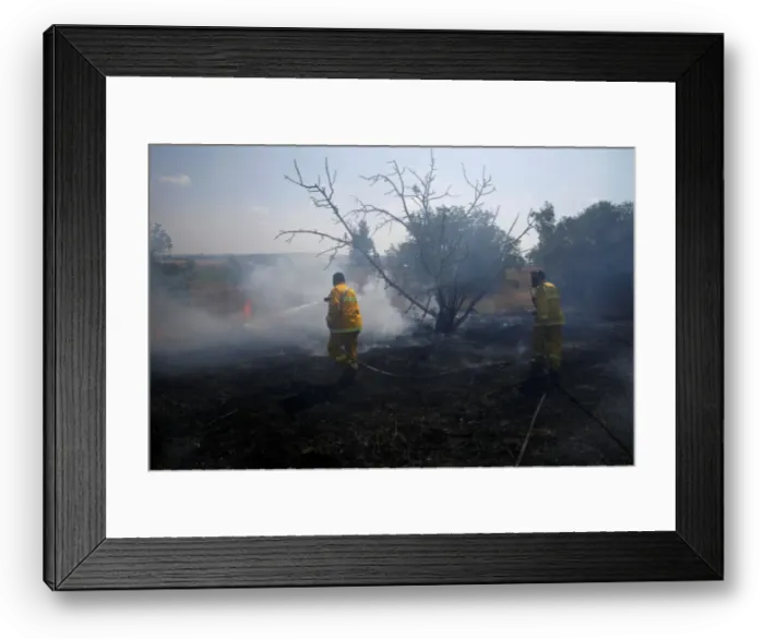 Framed Print : Firefighters try to extinguish fire on the Israeli side of the border fence between Framed Print : Firefighters try to extinguish fire on the Israeli side of the border fence between