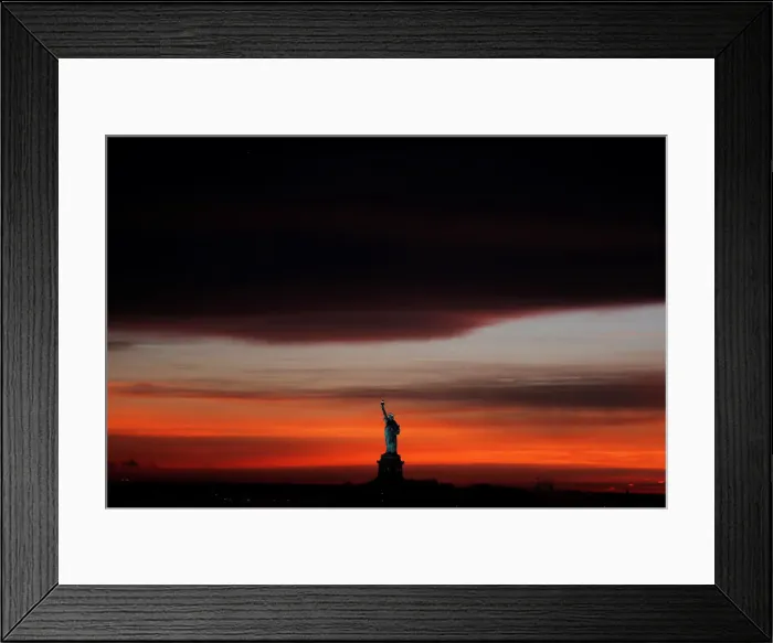Framed Print : The sun sets behind the Statue of Liberty after a rain storm in New York Framed Print : The sun sets behind the Statue of Liberty after a rain storm in New York
