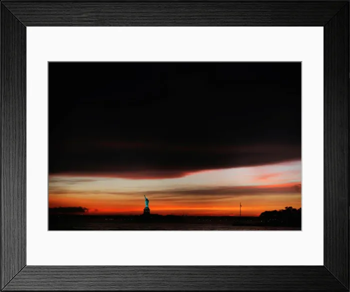 Framed Print : The sun sets behind the Statue of Liberty after a rain storm in New York Framed Print : The sun sets behind the Statue of Liberty after a rain storm in New York