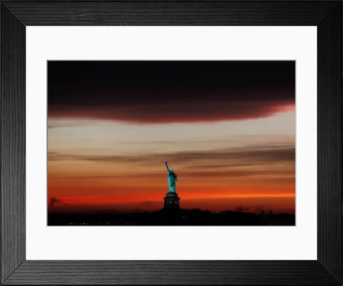 Framed Print : The sun sets behind the Statue of Liberty after a rain storm in New York Framed Print : The sun sets behind the Statue of Liberty after a rain storm in New York