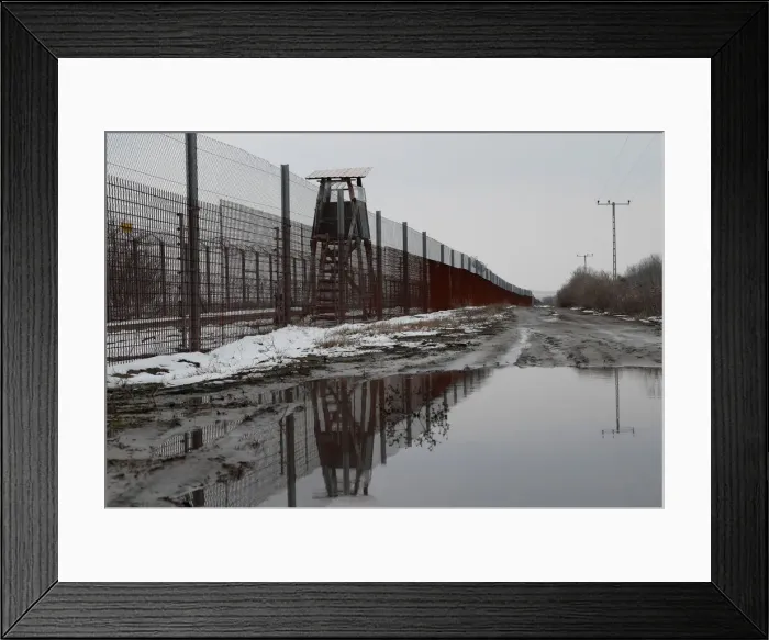 Framed Print : A wire fence is seen next to the village of Asotthalom Framed Print : A wire fence is seen next to the village of Asotthalom
