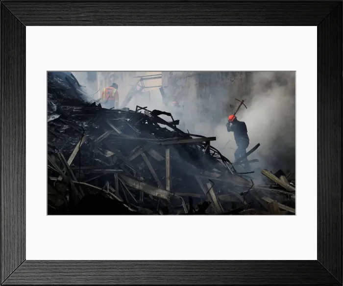Framed Print : Firefighters try to extinguish a fire of a building that caught fire Framed Print : Firefighters try to extinguish a fire of a building that caught fire