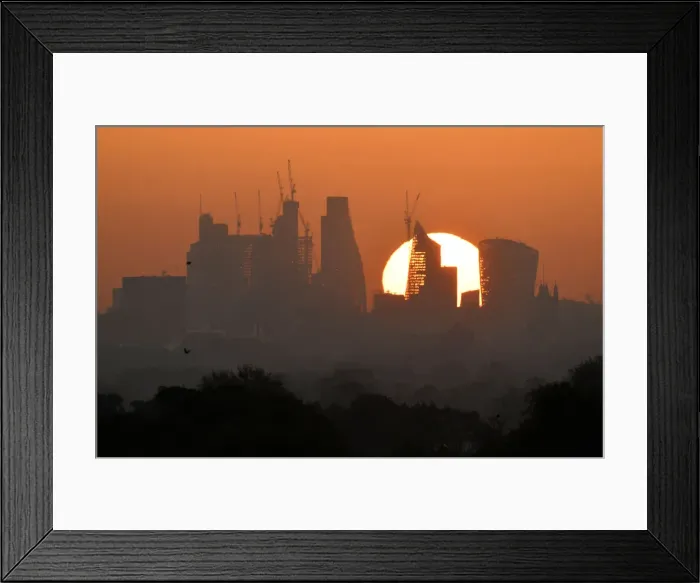 Framed Print : The sun is seen rising over skyscrapers in the City of London financial district in Framed Print : The sun is seen rising over skyscrapers in the City of London financial district in