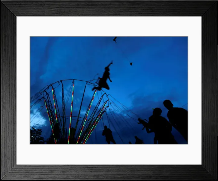 Framed Print : People ride on a swing carousel as part of the traditional celebration of Saint George s Framed Print : People ride on a swing carousel as part of the traditional celebration of Saint George s