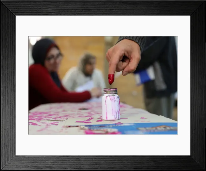 Framed Print : A voters finger is marked with ink at a polling station during the second day of