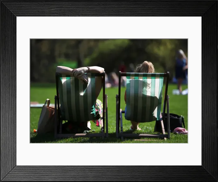 Framed Print : People lounge on deckchairs in the sunshine in St James Park, London Framed Print : People lounge on deckchairs in the sunshine in St James Park, London