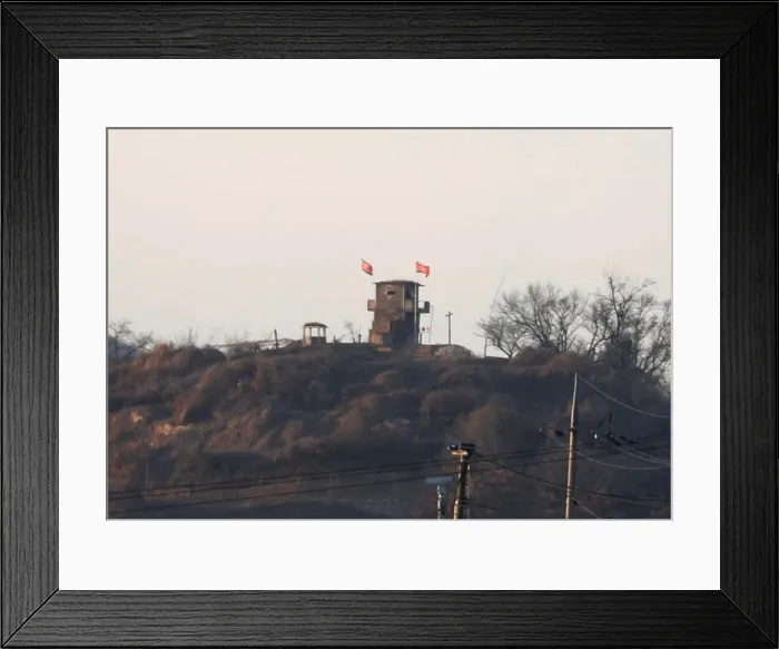 Framed Print : A North Korean flag flutters on the top of their guard post inside North Korean territory