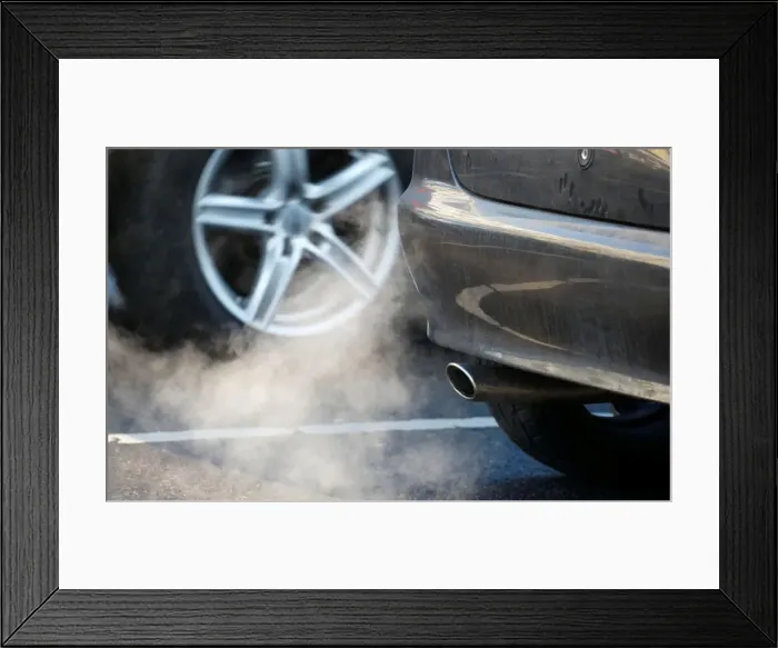 Framed Print : An exhaust pipe of a car is pictured on a street in a Berlin