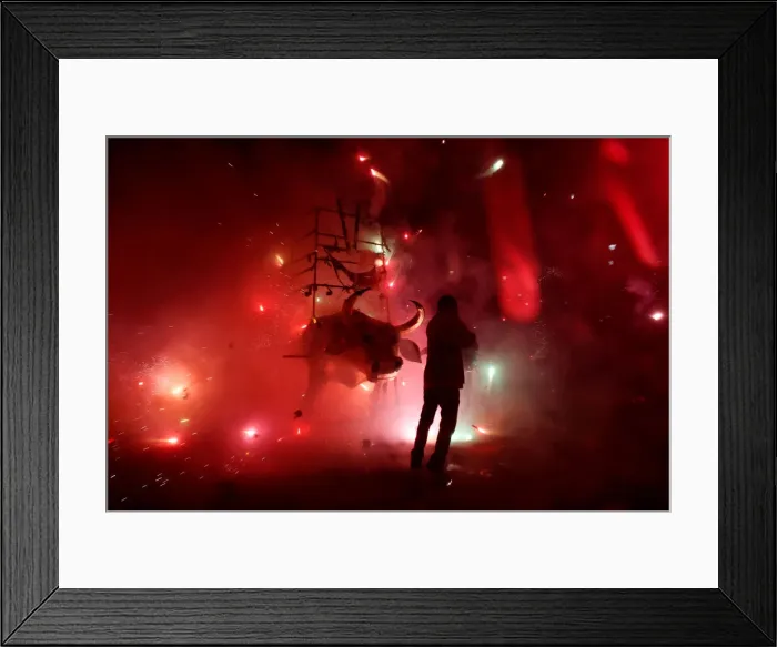 Framed Print : Man enjoys the fireworks exploding from a traditional bull figure known as El Torito in