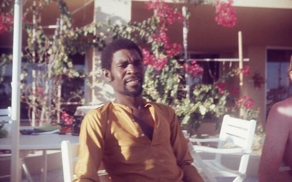 British Caribbean man sitting by pool at Holiday Inn Salalah