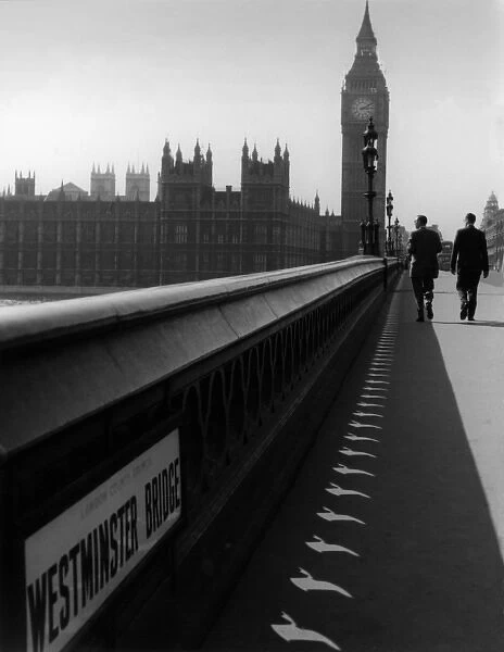 Two men walking over Westminster bridge