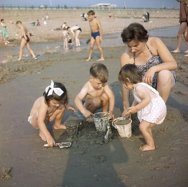 Mother and children on a sandy beach