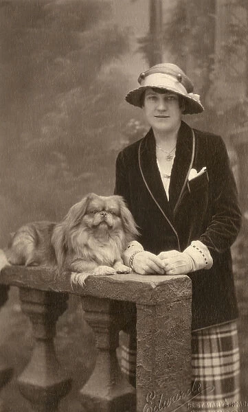 Studio portrait, woman with Pekingese dog