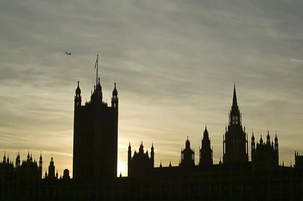 A plane flying over the Houses of Parliament London UK
