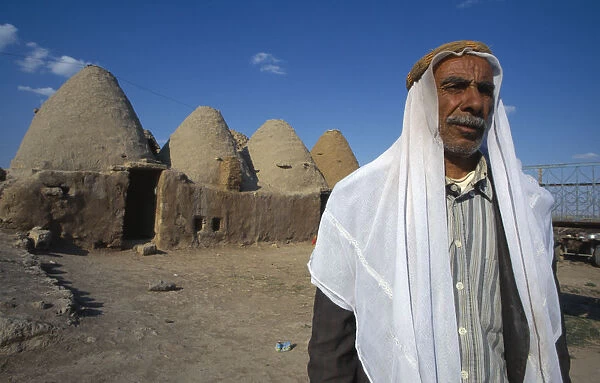 10127681. TURKEY Harran Old man stands outside beehive mud houses