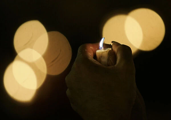 An activist holds a candle during celebrations of the International Day of Peace in
