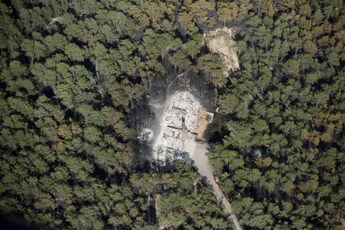 Framed Print : An aerial view of a destroyed house surrounded by dense forest in the aftermath of Framed Print : An aerial view of a destroyed house surrounded by dense forest in the aftermath of