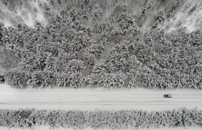 Framed Print : An aerial view shows a car driving along a forest road after snowfall outside Krasnoyarsk