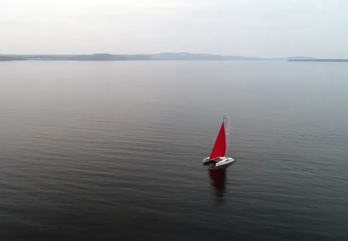 Framed Print : Aerial view shows a couple traveling on a sailing catamaran along the Yenisei River Framed Print : Aerial view shows a couple traveling on a sailing catamaran along the Yenisei River