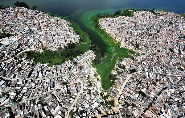 An aerial view shows illegally built slums on the border of the polluted water of